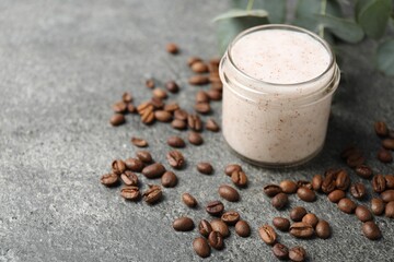 Natural body scrub in glass jar, coffee beans and eucalyptus branches, closeup. Space for text