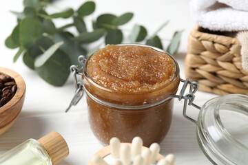 Natural body scrub, ingredients, brush and towels on white wooden table, closeup