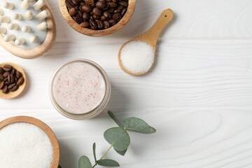 Natural body scrub in glass jar, ingredients and brush on white wooden table, flat lay. Space for text