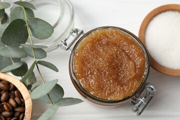 Natural body scrub in glass jar and ingredients on white wooden table, flat lay