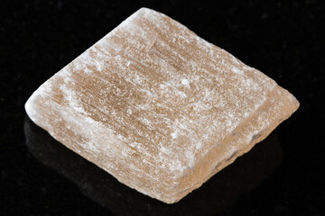 sample of raw selenite mineral on black granite