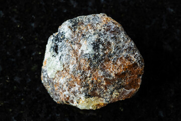 sample of raw brown titanite mineral on black