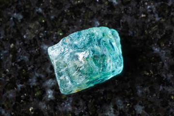 raw starlite blue zircon mineral on black granite