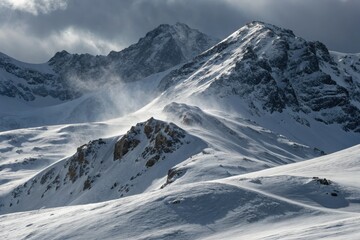 Snowy Mountain Peaks Surrounded by Wispy Clouds in Winter Landscape