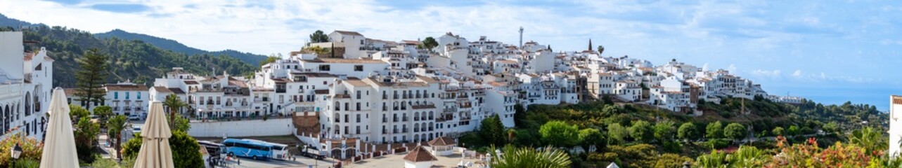 Fototapeta premium A peaceful walk through the charming narrow streets, surrounded by whitewashed houses and colorful flowers in Frigiliana, Spain