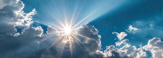 Sunbeams piercing through fluffy clouds against a vibrant blue sky