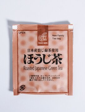 Jakarta, Indonesia - August 11th, 2025 - OSK roasted japanese green tea object with brown paper packaging isolated on vertical white background.
