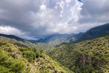 Scenic view of surrounding mountains and picturesque village from a hiking trail along an old irrigation ditch in Frigiliana, Spain.