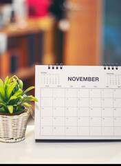 Desktop calendar and cactus placed on student wooden desk in living room, calender for planner to plan daily appointments each day, month, and year on wooden table-vertical image.