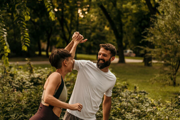Fototapeta premium Happy couple giving high five while running in park