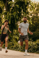 Fototapeta premium Happy couple running and smiling in city park
