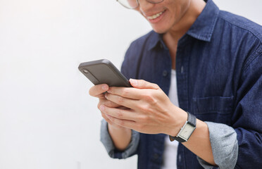 close up businessman hand hold smartphone to surfing the internet and check work or mail on website while sit in the living room in weekend for business technology and lifestyle concept