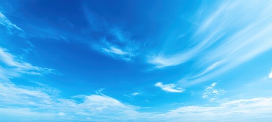 The expansive blue sky with wispy clouds on a sunny day.