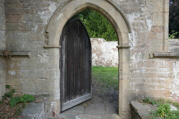All Saints Church, Annesley, Nottingham, England – August 10 2025: Medieval stone archway and wooden door at historic Nottinghamshire church entrance