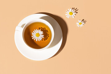 Chamomile tea cup with chamomile flowers on blue