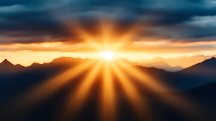 Dramatic sunburst breaks through dark storm clouds over mountain silhouettes at sunset, creating powerful rays of golden light against moody sky background.