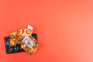 Empty pills and blister packs in various shapes on a vibrant red surface, top view