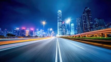 Obraz premium Modern Cityscape at Night: Dynamic Road Perspective with Illuminated Skyscrapers and Vibrant Urban Ambiance