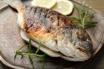 Tasty roasted dorado fish and spices on table, closeup. Homemade seafood dish