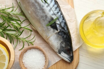 Fresh raw mackerel and spices on light wooden table, flat lay. Seafood delicacies