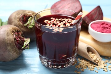 Superfood. Tasty juice with oats in glass and beetroots on light blue wooden table, closeup