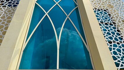Architectural window showcasing geometric design with blue glass reflects sky for high resolution photo