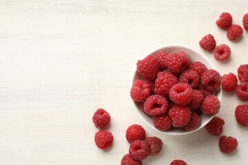 Tasty fresh ripe raspberries on white wooden table, flat lay. Space for text