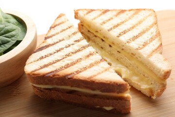 Tasty sandwiches with melted cheese and spinach on table, closeup
