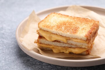 Tasty sandwiches with melted cheese and parsley on grey table, closeup