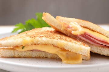 Delicious sandwiches with melted cheese and ham on table, closeup