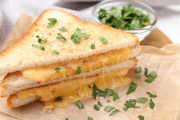 Delicious sandwiches with melted cheese and parsley on table, closeup