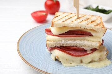 Delicious sandwich with melted cheese and ham on white table, closeup