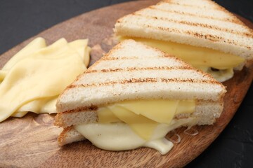 Tasty sandwiches with melted cheese on table, closeup