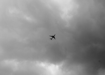 Black and White picture of an Airplane Flying on a Cloudy Day