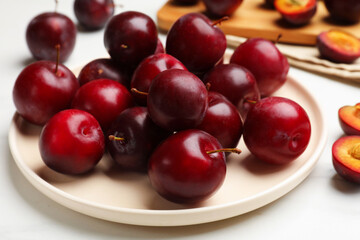Ripe cherry plums on white table, closeup