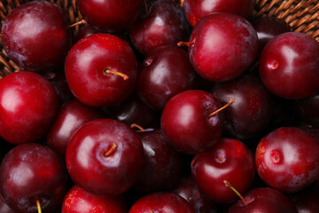 Ripe cherry plums in wicker basket, above view
