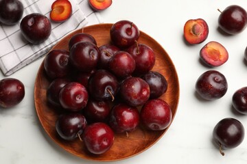 Ripe cherry plums on white table, flat lay