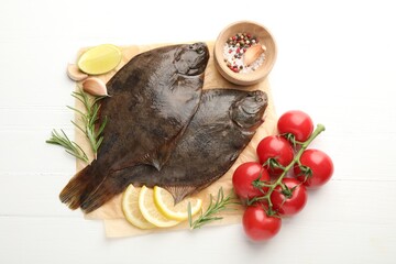 Fresh raw flounder fish and ingredients on white wooden table, flat lay. Seafood