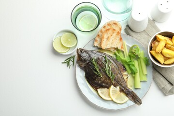 Homemade seafood dish. Tasty roasted flounder fish with celery served on white table, flat lay. Space for text
