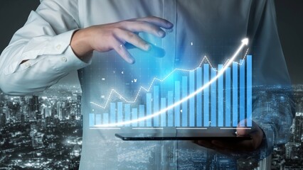 A businessman presents a digital tablet showcasing a 3D graph with growth trends against a stunning night city background. Perfect for finance and technology themes. Copula