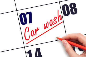 7th day of the month.  Hand writing Car wash reminder and drawing a line on calendar with red pen...