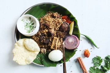 Homecooked Dindigul Thalappakatti mutton biryani served with yogurt pickle and pappad
