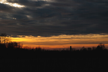 tramonto arancione con cielo nuvoloso da un ambiente naturale della campagna del nord Italia, in inverno