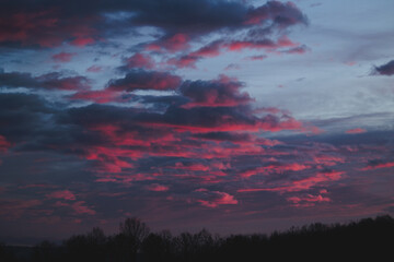 bellissimo e particolare tramonto dalle sfumature brillanti di colore rosso e magenta, visto da un ambiente naturale e rurale delle campagne del nord Italia, in inverno