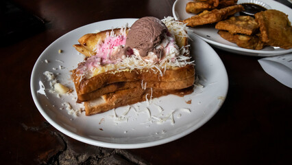 toast, ice cream and cheese flakes on a white plate on the table
