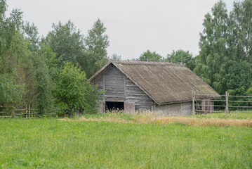 A secluded wooden house in the countryside. A picturesque cottage in an abandoned valley. A wooden barn in a village meadow. An old abandoned farm on a hill.