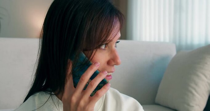 College student reviewing notes and consulting with classmate by phone. Academic self-study in living room