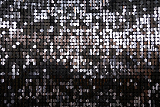 A visually striking close-up of a metallic sequined surface, reflecting light in various shades, ideal for themes of glamour and celebration