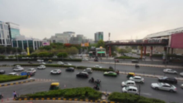 Blurred top side view of the road traffic in Gurgaon with DLF CyberHub at the background near Cyber City metro station, India. Bokeh time lapse motion video for background.	