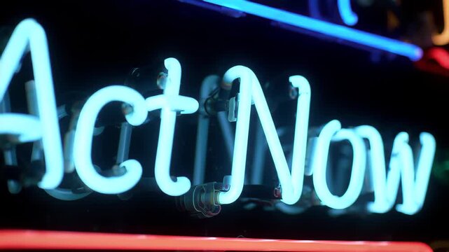Close Up Of Glowing Blue Neon Sign Act Now At Night